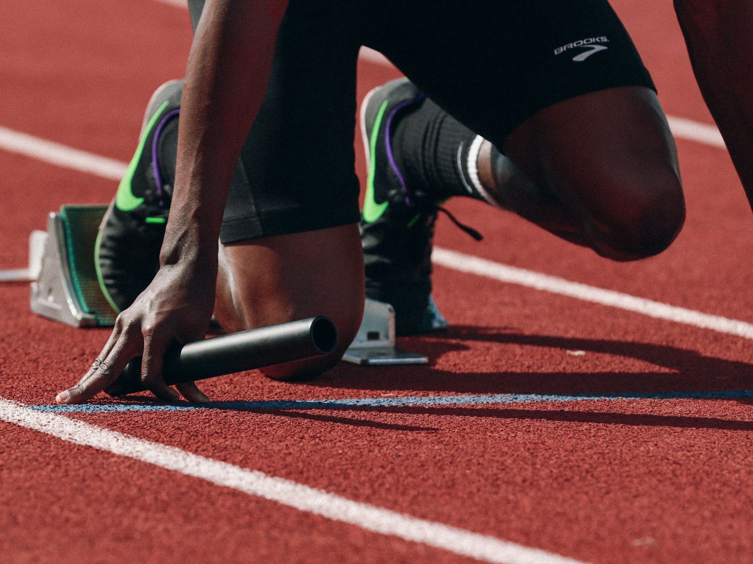 A sprinter at the blocks on a stadium track